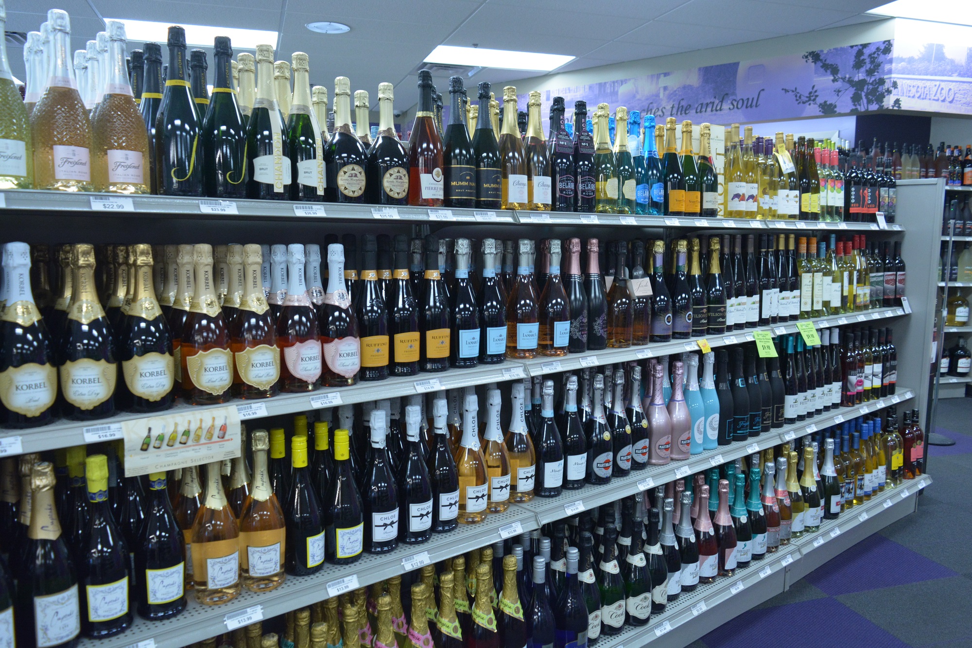 Organized rows of bottled champagne and sparkling wines on display at Apple Valley Liquor store 2.