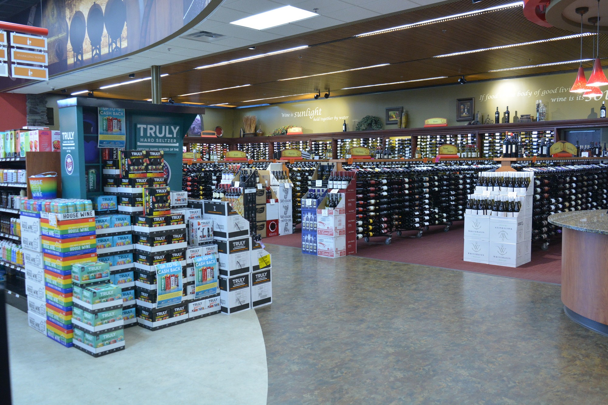 Well-organized wine department at Apple Valley Liquor store 3 with carpeted aisles and decorative wall murals.