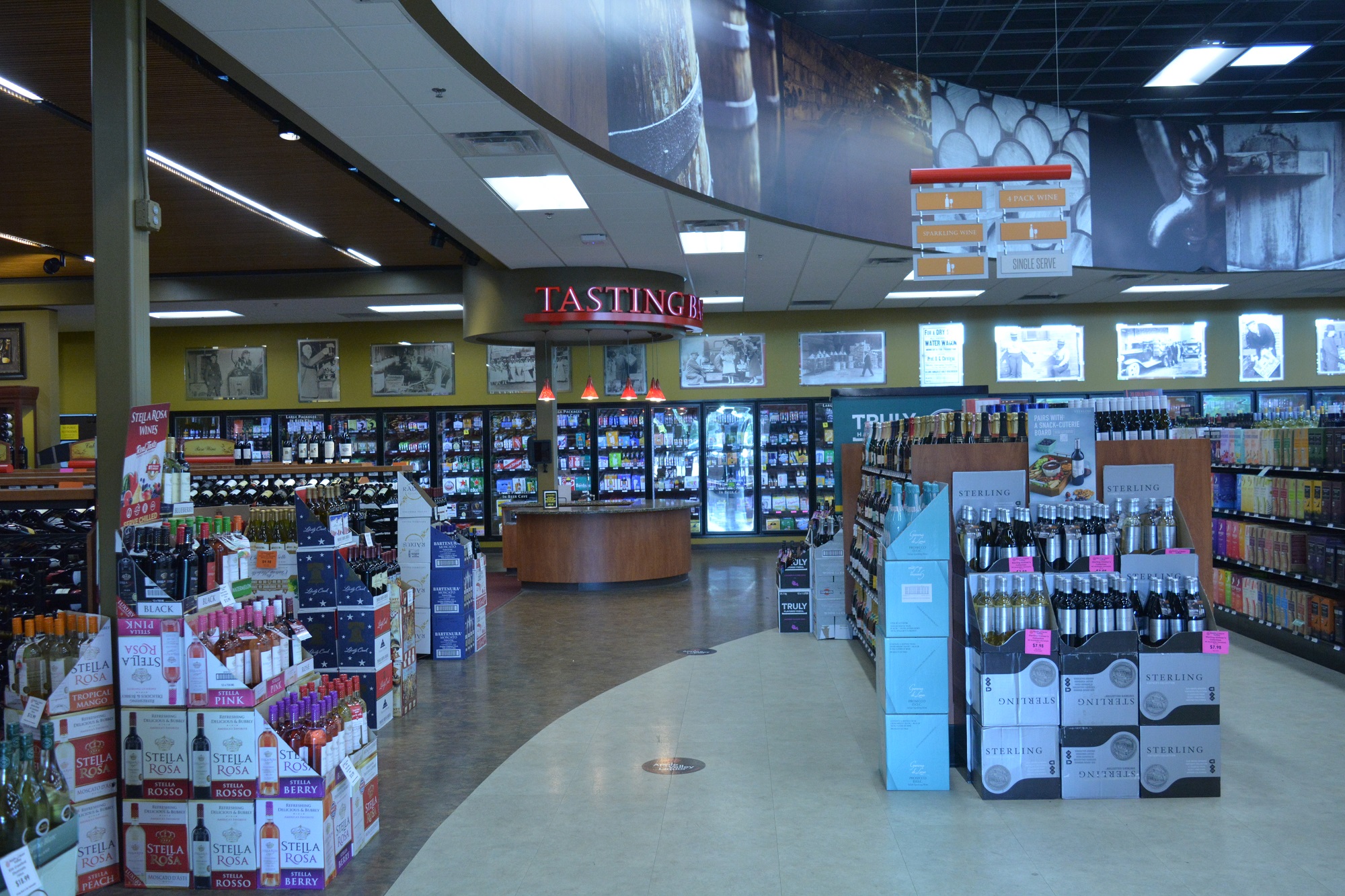 Interior of Apple Valley Liquor store 3 showing wide aisles, boxed wine displays, and hanging signage.
