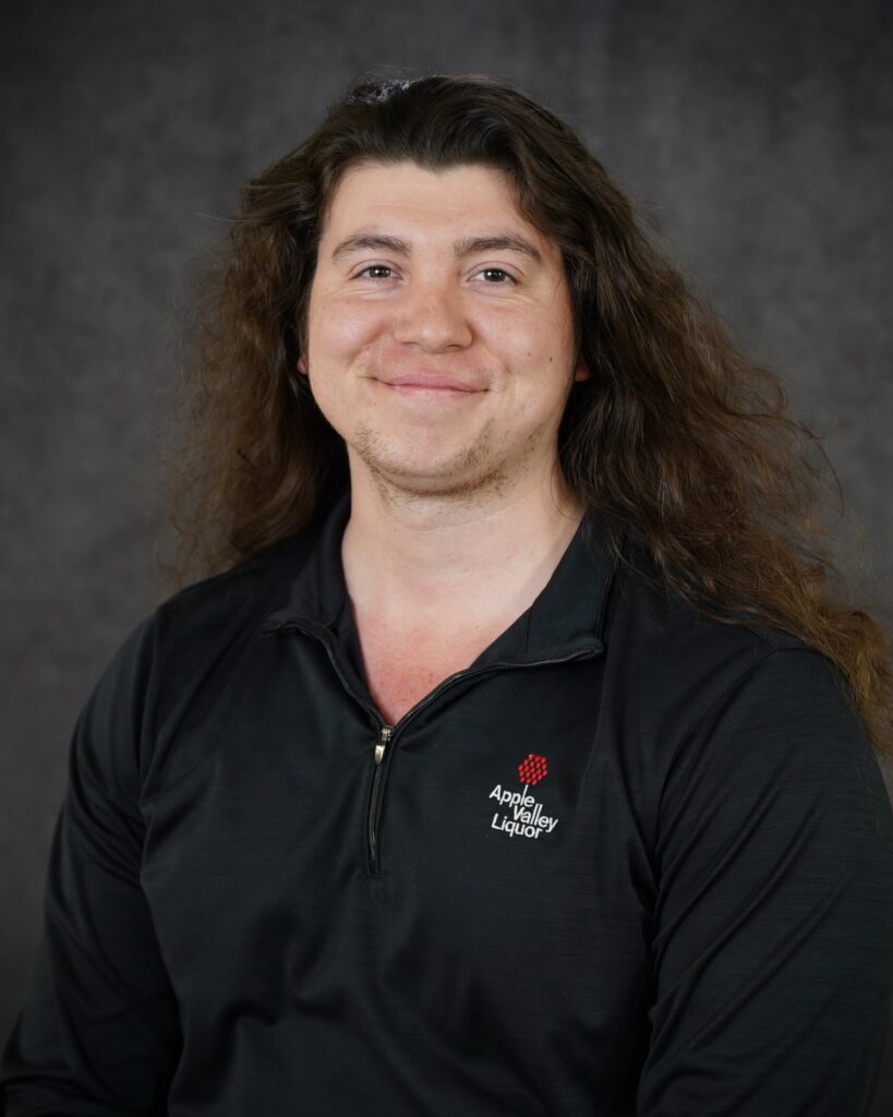 Cam Kennedy, Liquor Store #1 Assistant Manager headshot with Apple Valley Liquor quarter zip