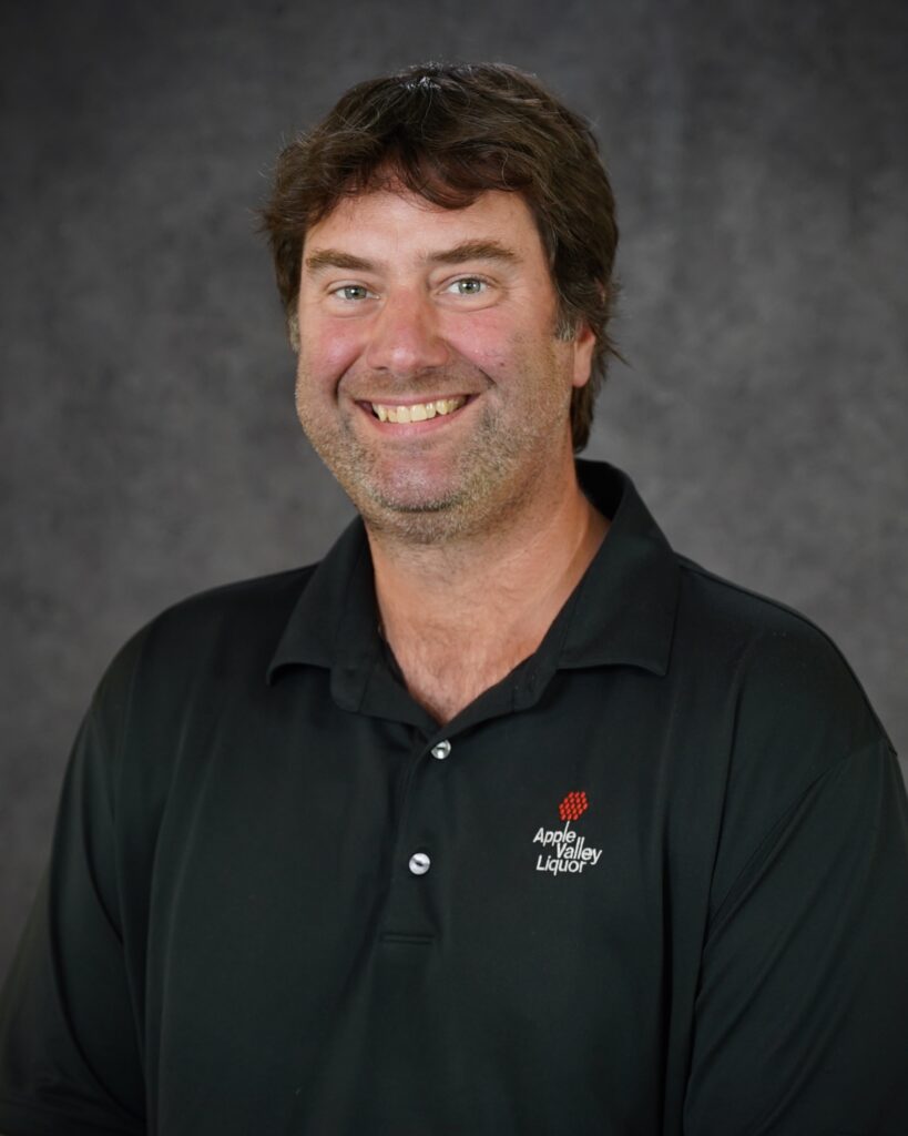 Steve Schuft, Liquor Operations Assistant Director headshot with Apple Valley Liquor polo