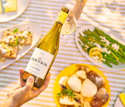 Clos du Bois wine bottle held over a picnic table