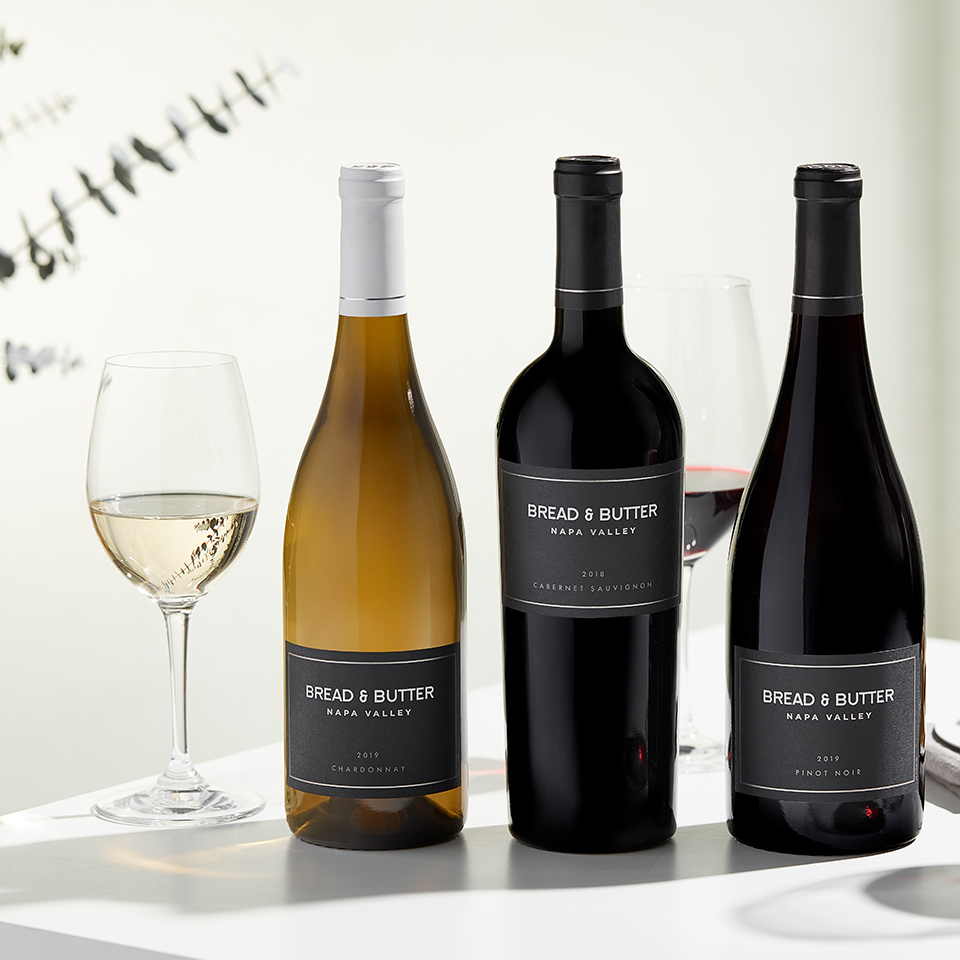 Three bottles of Bread & Butter wine with a wine glass next to them.